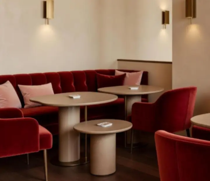 Vue nocturne du salon de divertissement d'Atelier Cerise, avec canapés en velours et tables de jeu élégantes